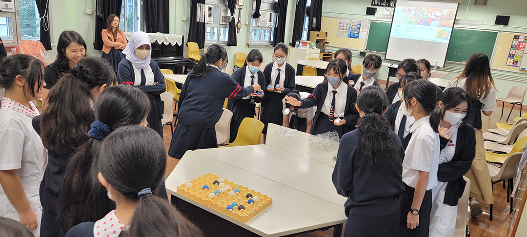 A group of people standing next to a table with colorful platesDescription automatically generated