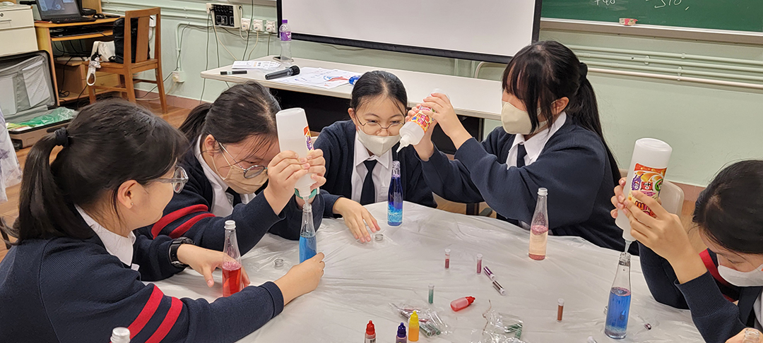A group of people wearing face masks sitting at a tableDescription automatically generated