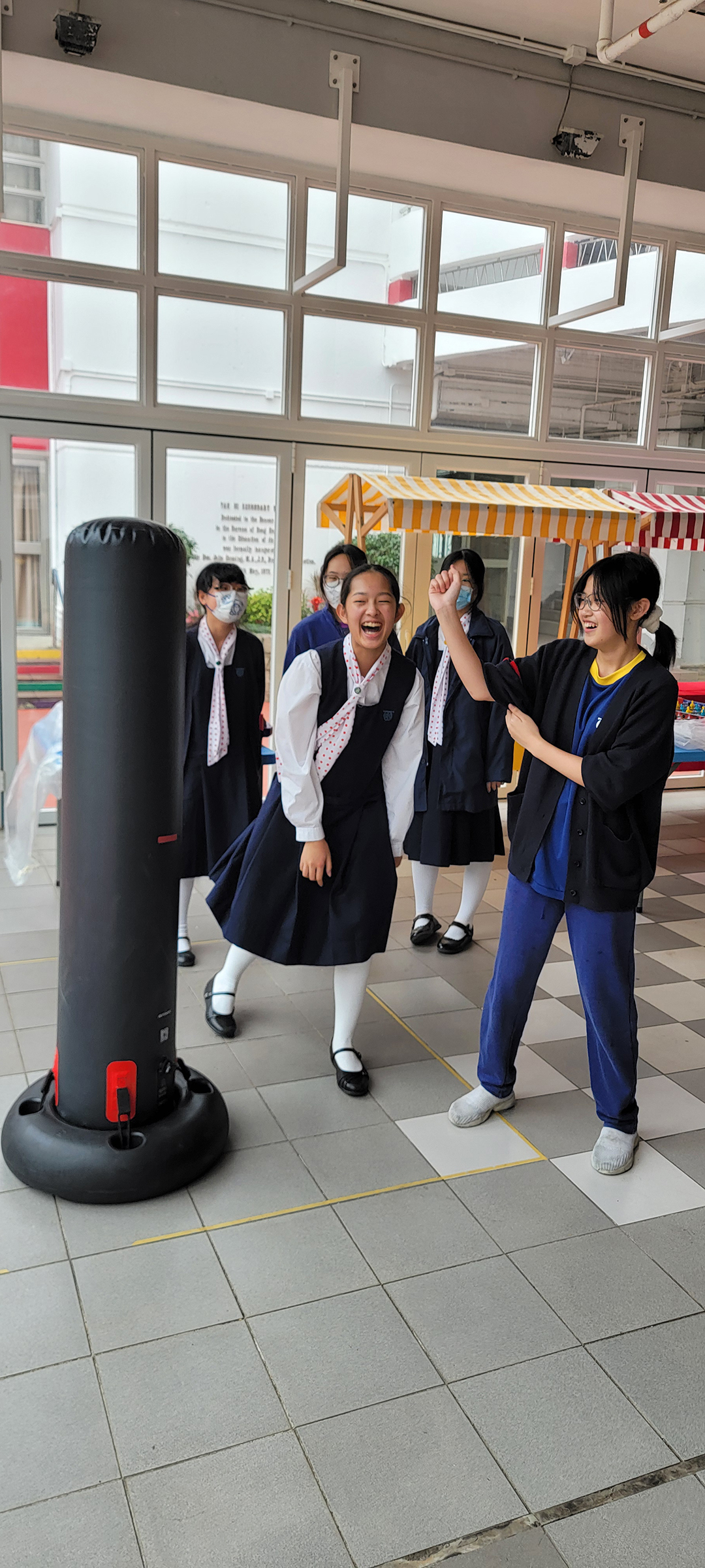 A person in a black shirt with a mask in front of a screenDescription automatically generated