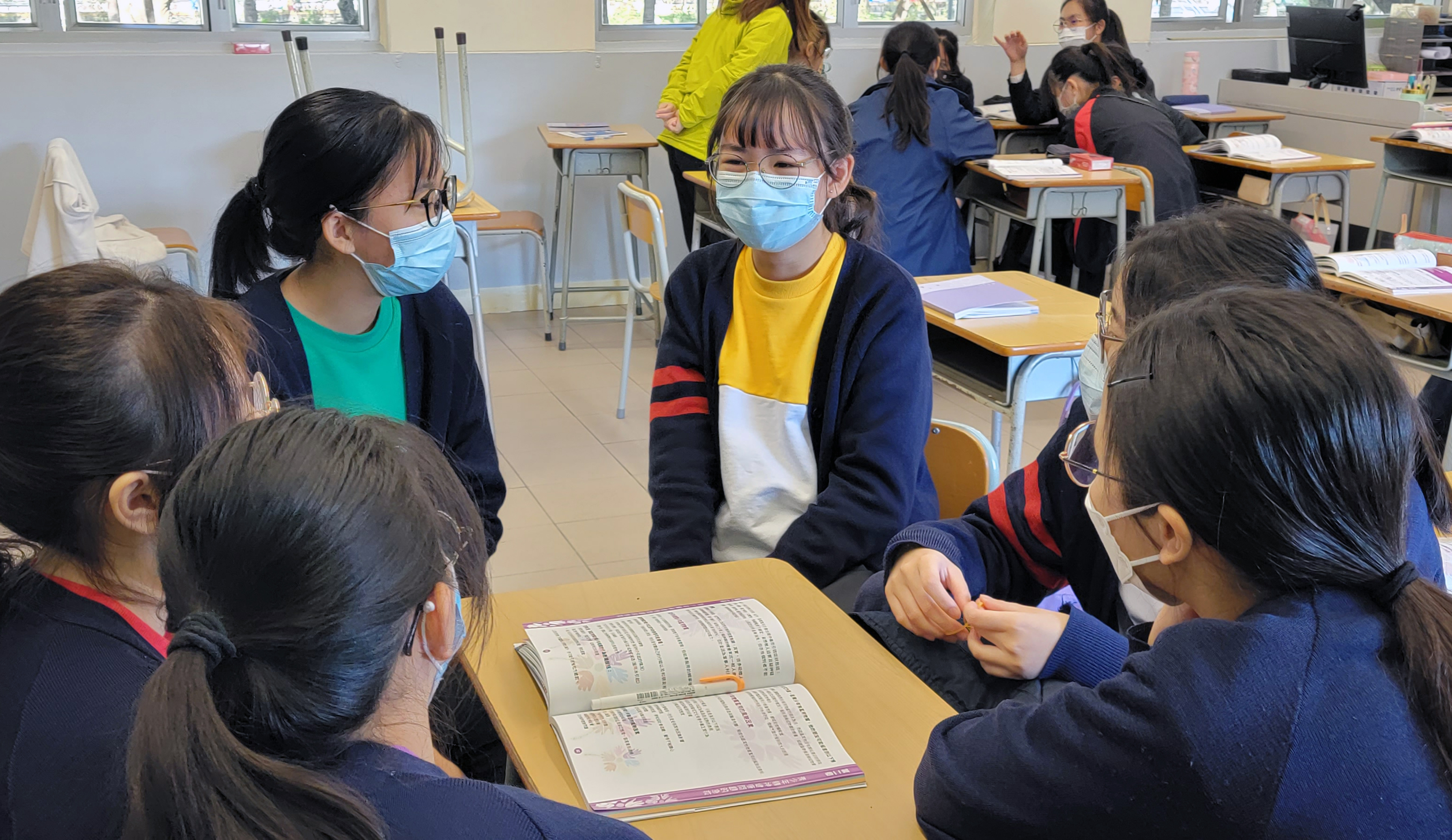 A group of students wearing face masks in a classroomDescription automatically generated