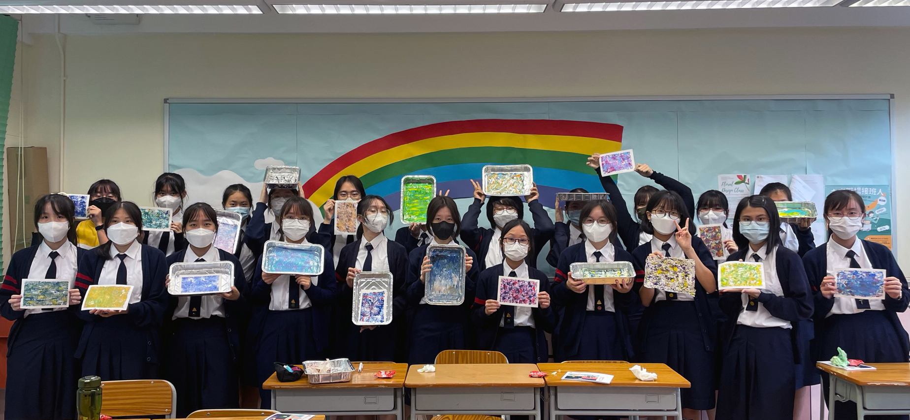 A group of students holding up their facesDescription automatically generated