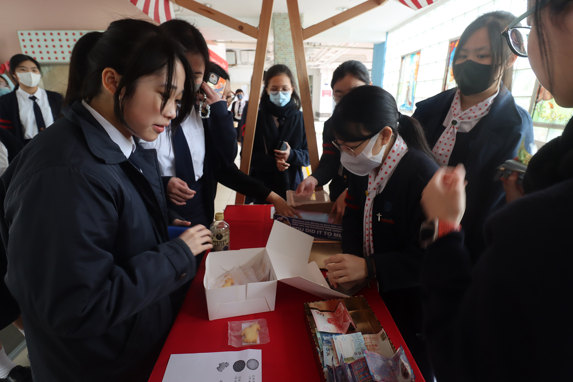 A group of girls wearing masks and standing in front of a statueDescription automatically generated