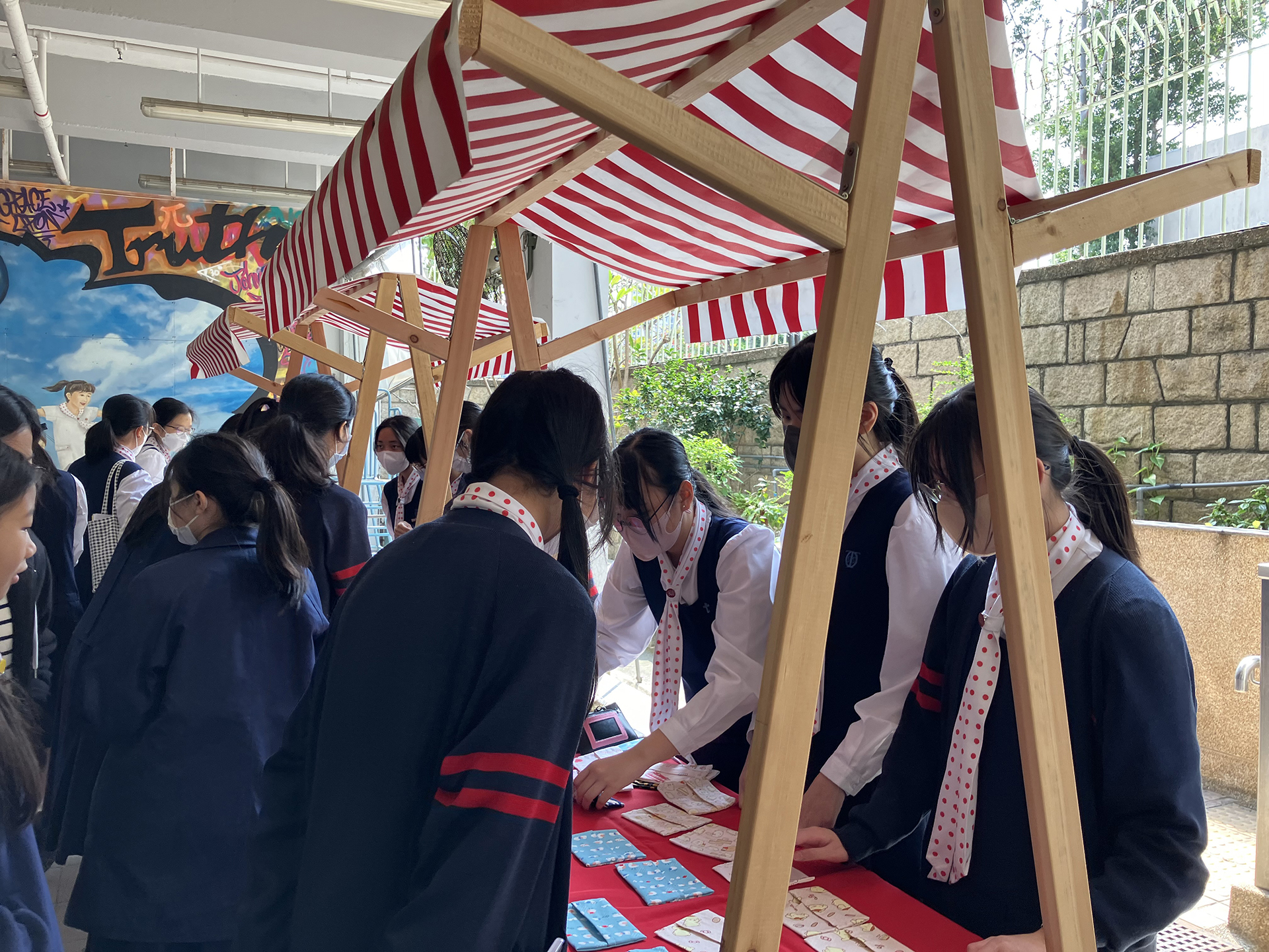 A group of girls wearing masks and standing in front of a statueDescription automatically generated