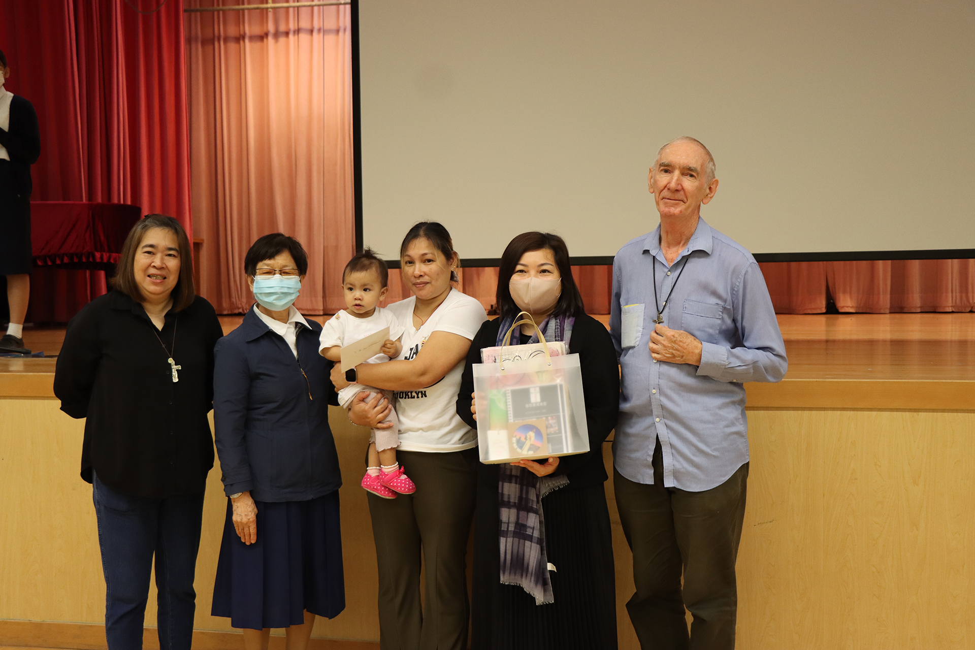 A group of girls wearing masks and standing in front of a statueDescription automatically generated