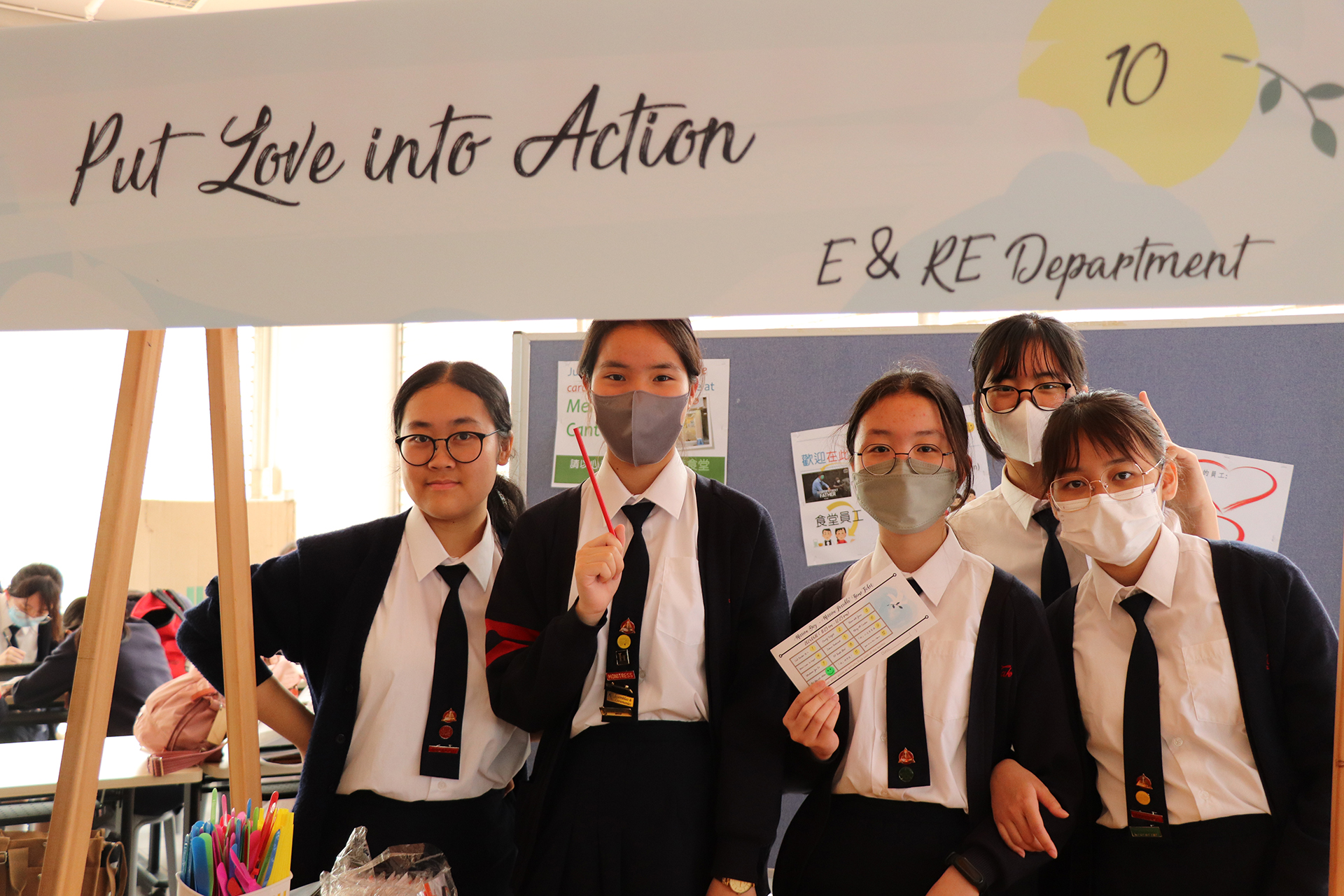 A group of girls wearing masks and standing in front of a statueDescription automatically generated