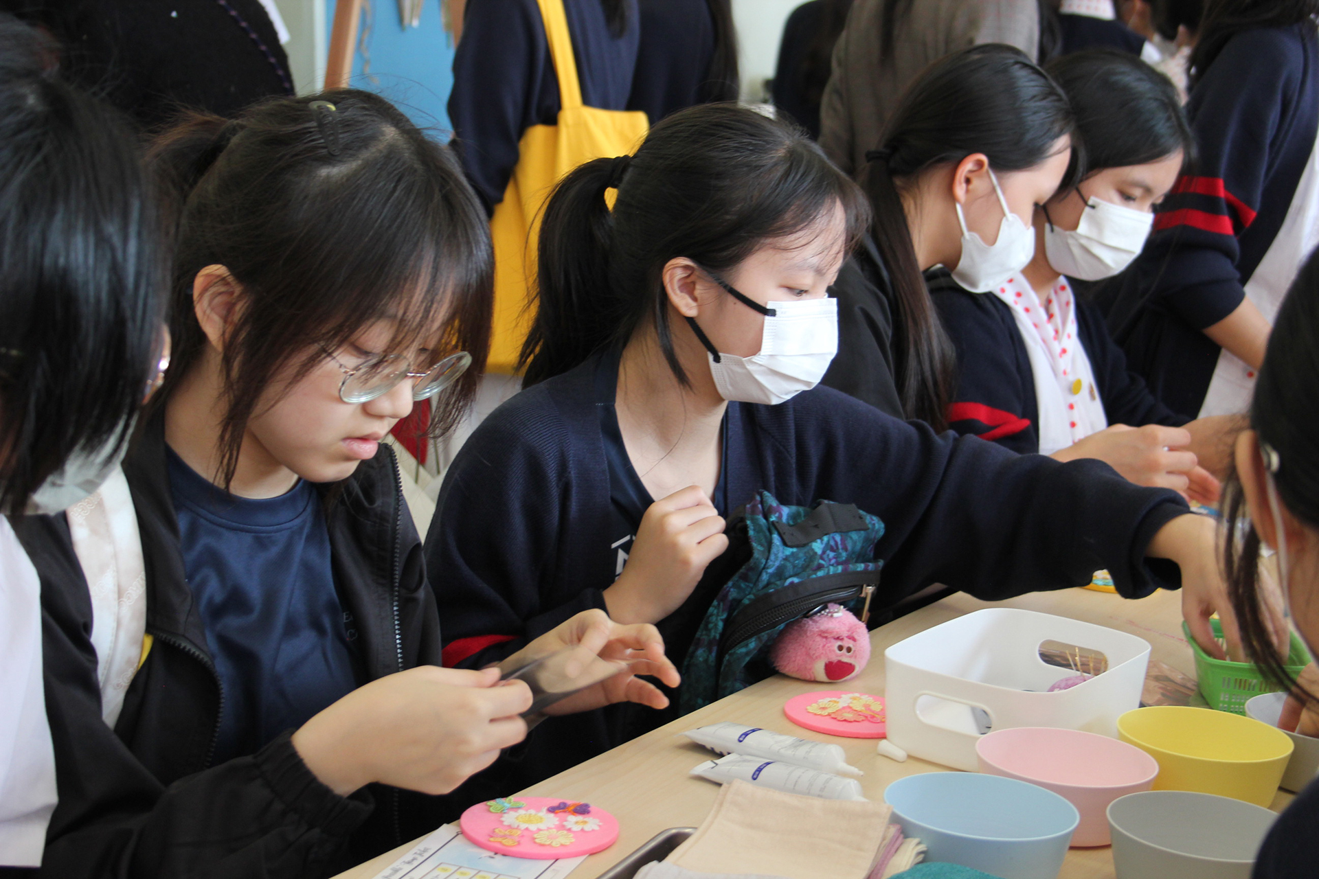 A group of girls wearing masks and standing in front of a statueDescription automatically generated