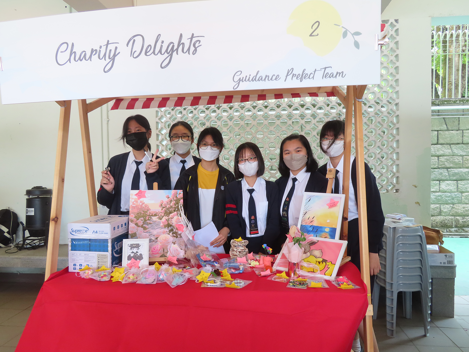 A group of girls wearing masks and standing in front of a statueDescription automatically generated