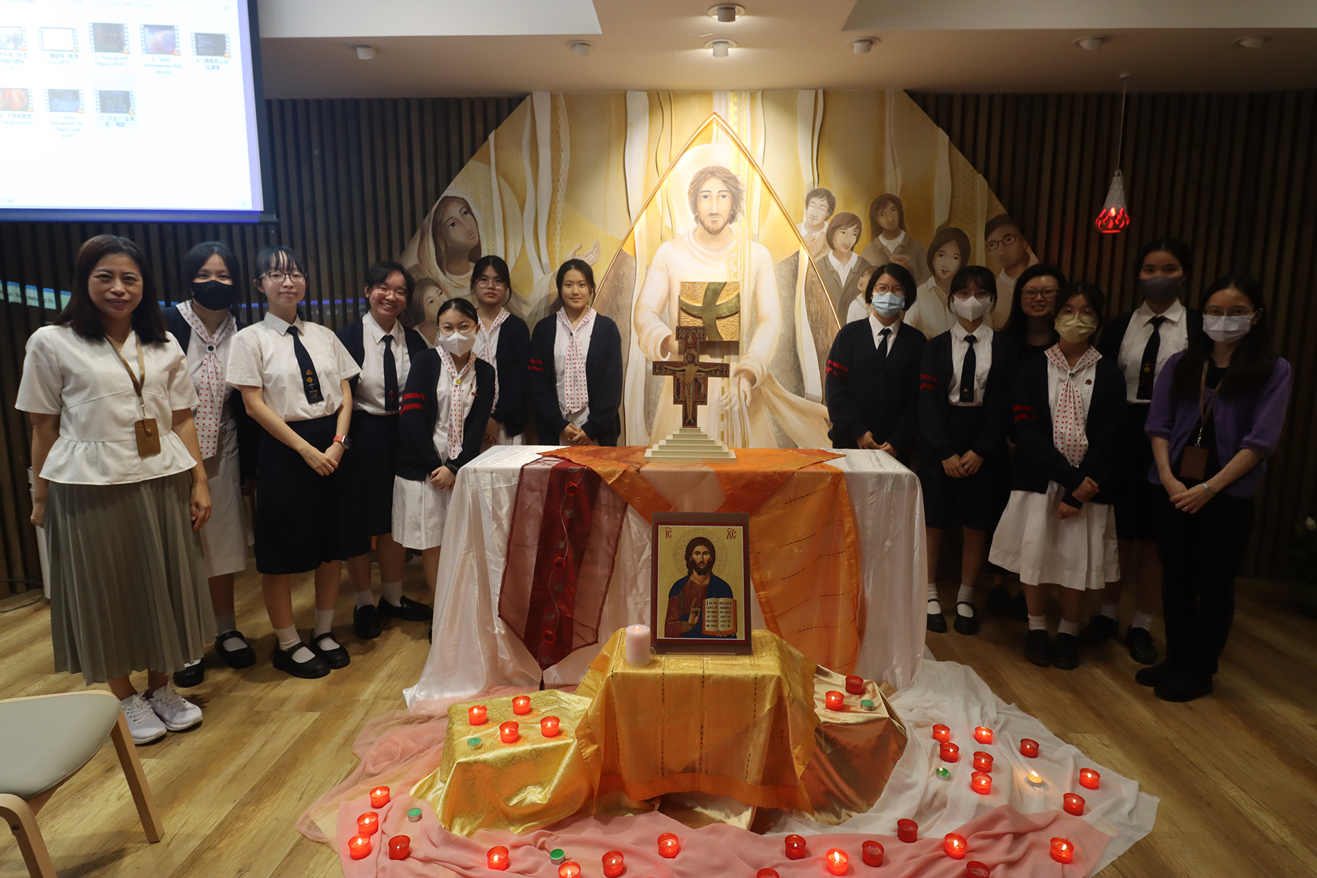 A group of girls wearing masks and standing in front of a statueDescription automatically generated