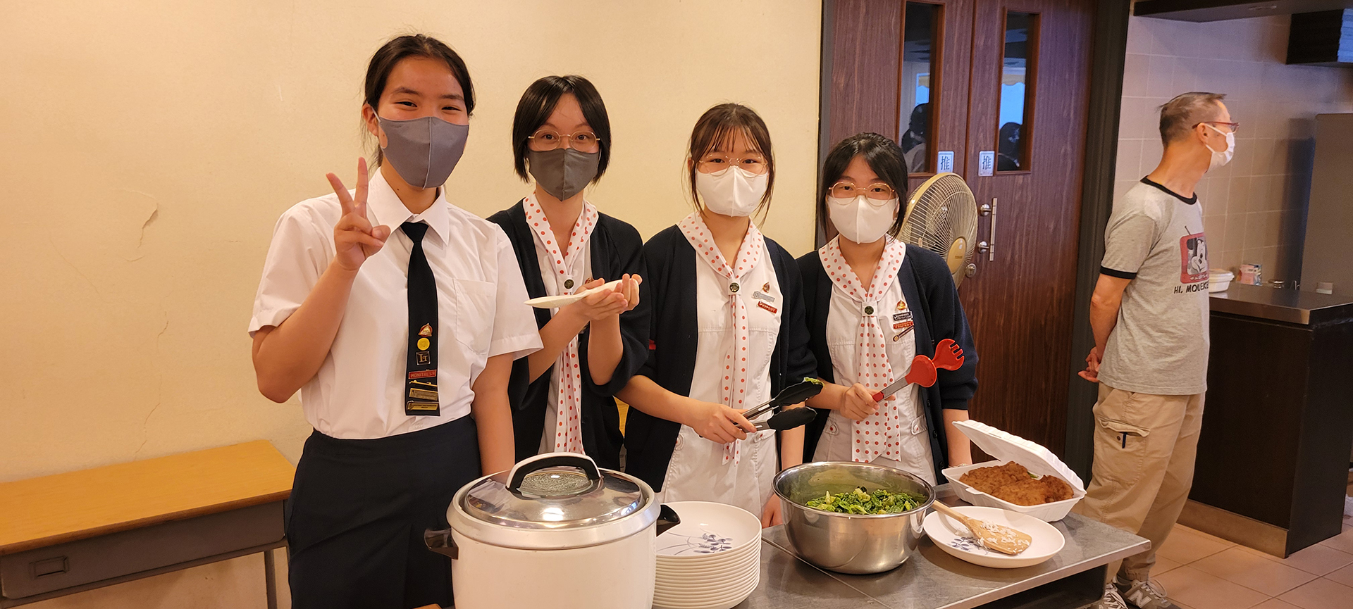 A group of girls wearing masks and standing in front of a statueDescription automatically generated