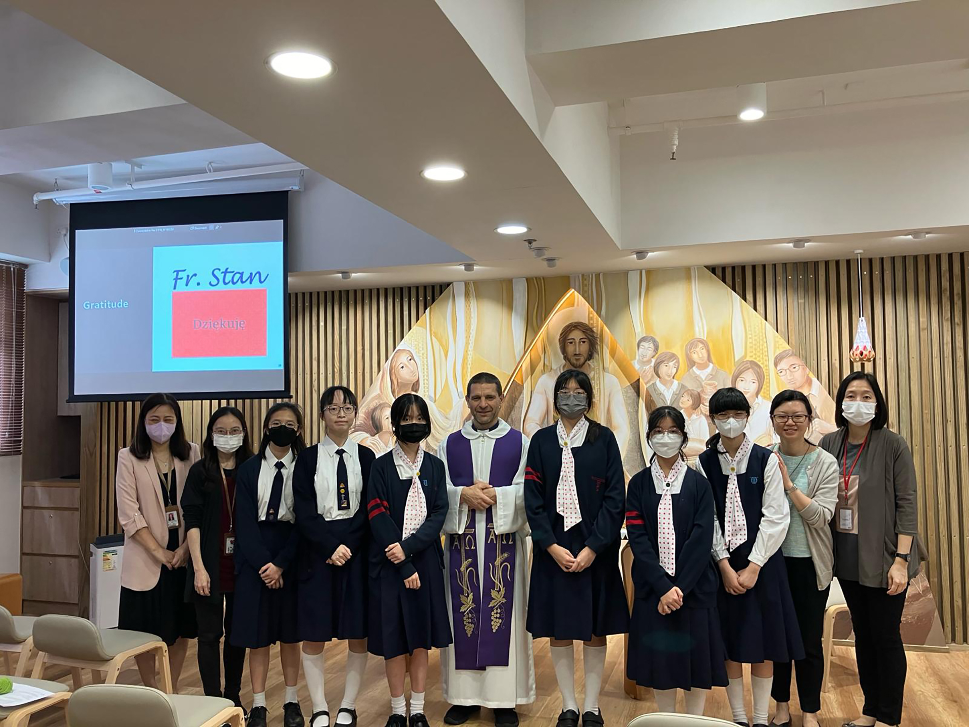 A group of girls wearing masks and standing in front of a statueDescription automatically generated