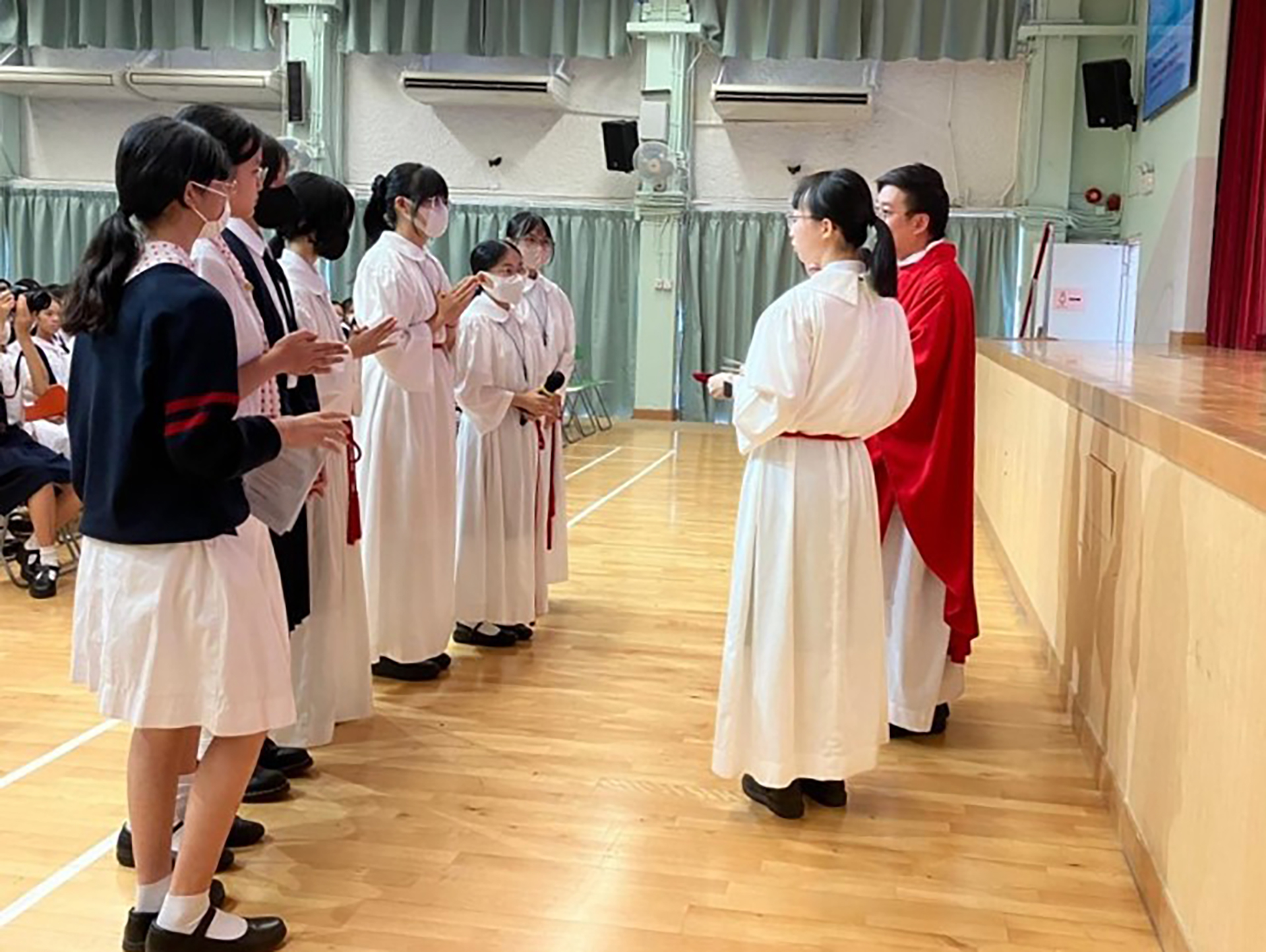 A group of girls wearing masks and standing in front of a statueDescription automatically generated