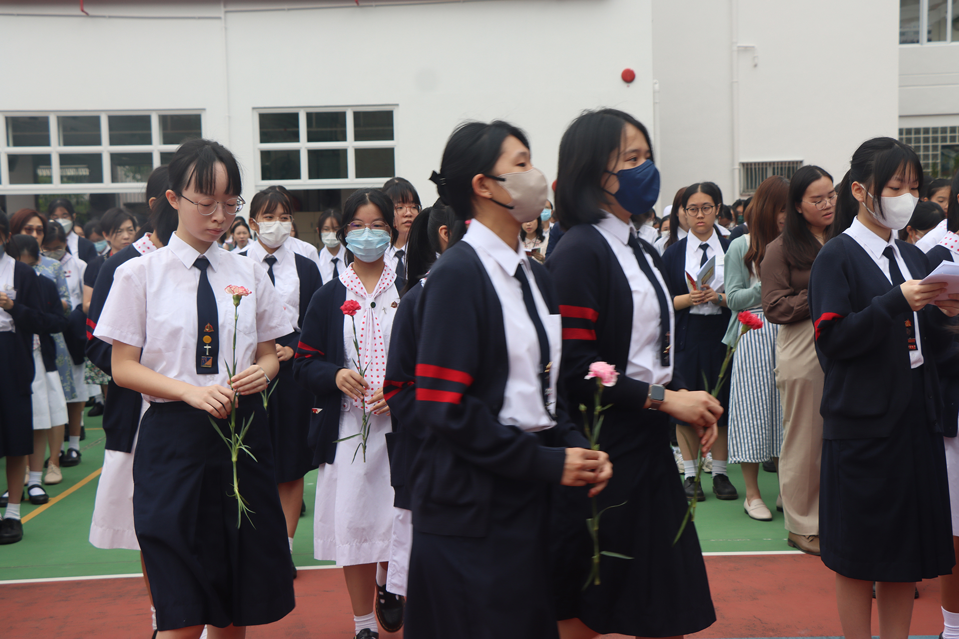 A group of people standing in front of a statueDescription automatically generated