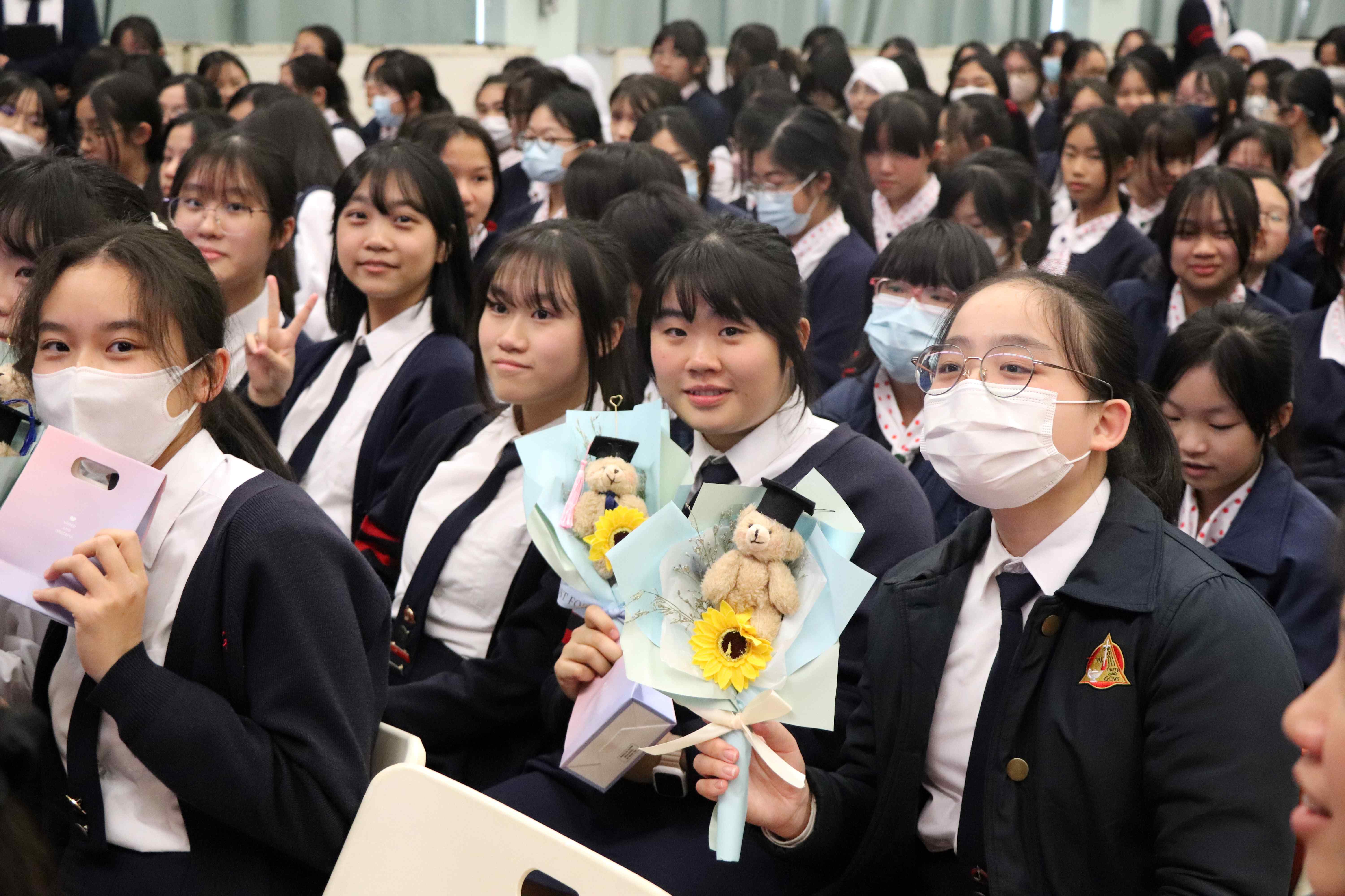 A group of girls wearing masks and standing in front of a statueDescription automatically generated