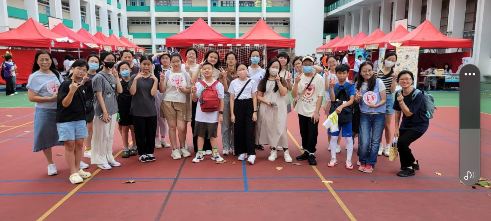 A group of girls wearing masks and standing in front of a statueDescription automatically generated