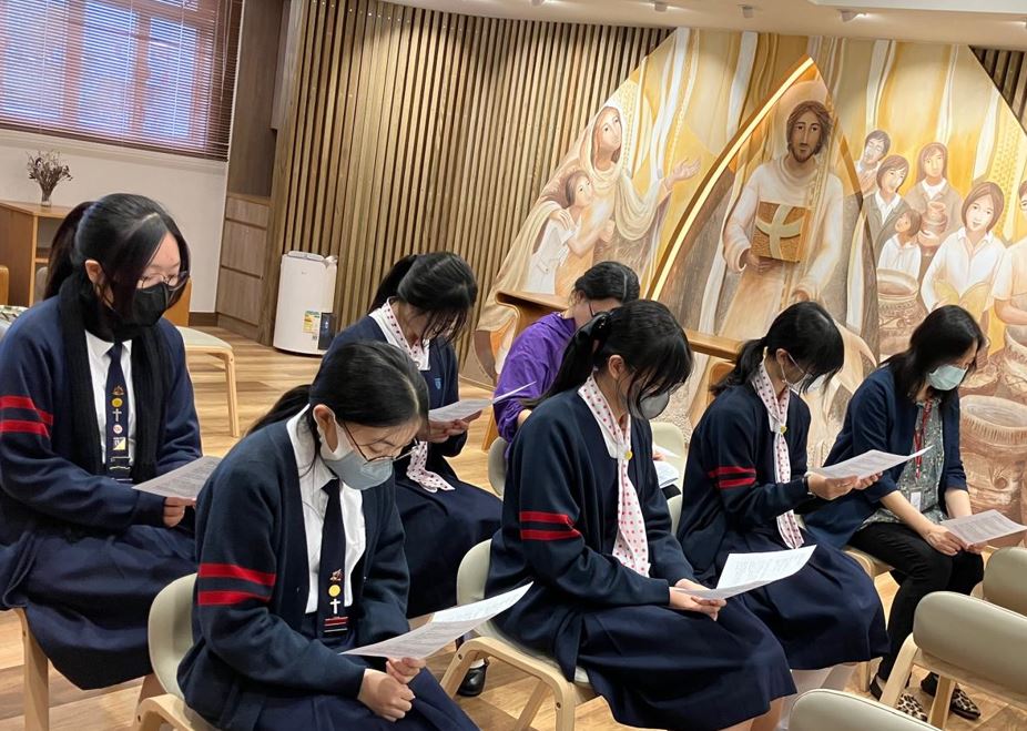 A group of girls wearing masks and standing in front of a statueDescription automatically generated