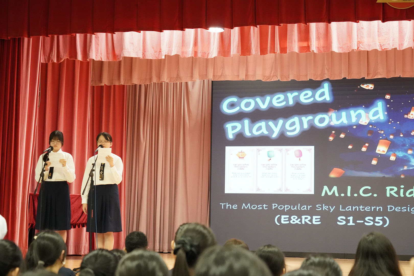 A person standing in front of a bannerDescription automatically generated